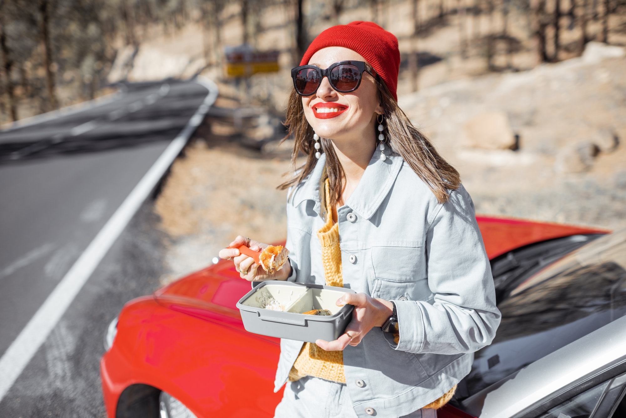 Woman eating during a roadtrip in the mountains