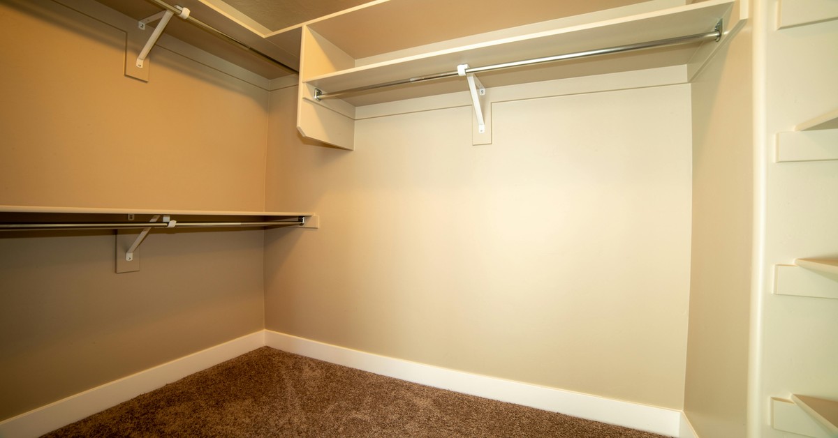 Adjustable shelving system in a tall closet with tracks and brackets for custom vertical storage