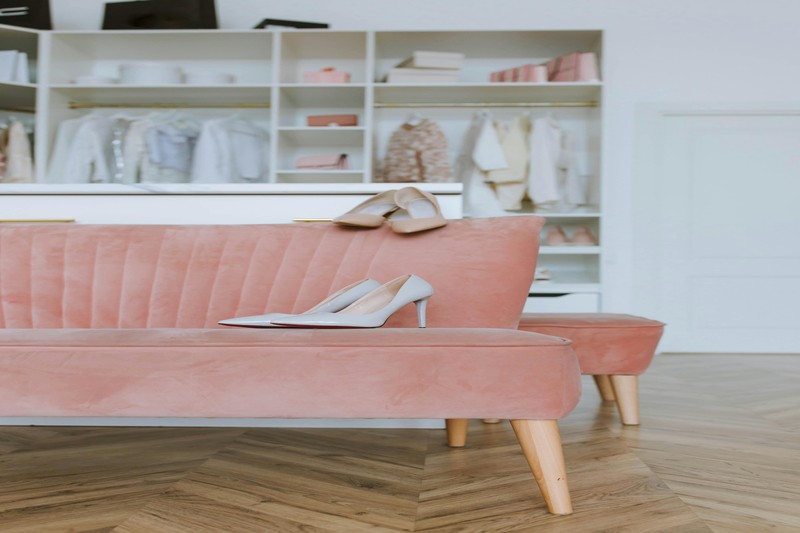 Acrylic shoe boxes and velvet hangers on a closet shelf