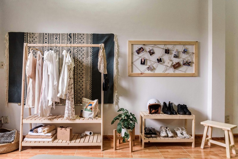 Stylish bamboo clothes rack in a modern living room with hanging clothes