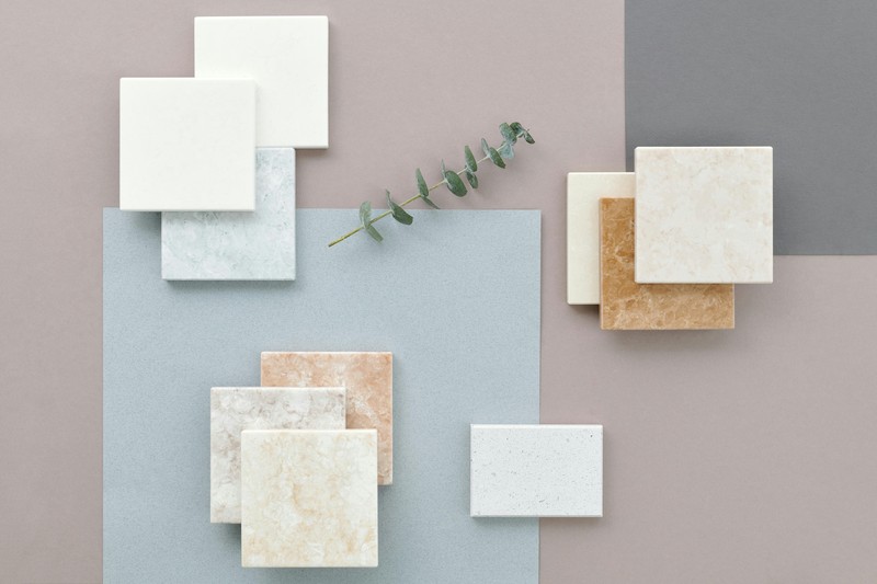 Paint swatches of beige, cream, and grey on a closet wall for testing