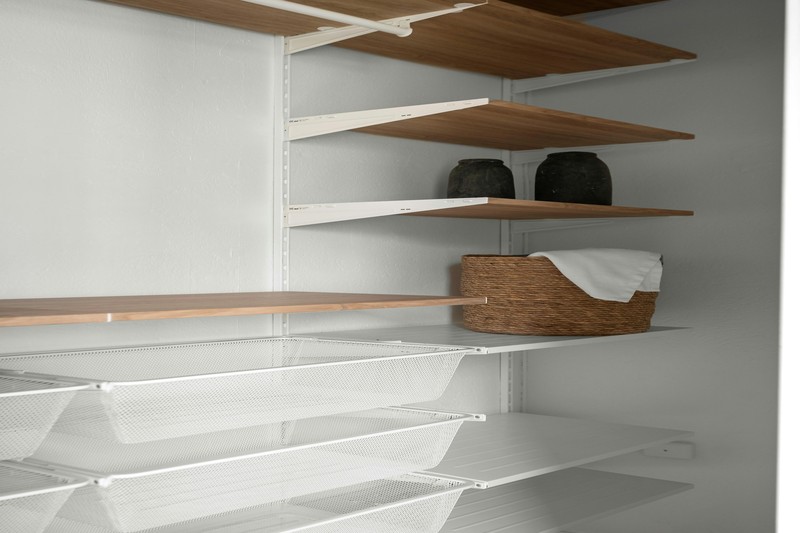 Budget-friendly IKEA PAX closet system with white doors and open wood shelves