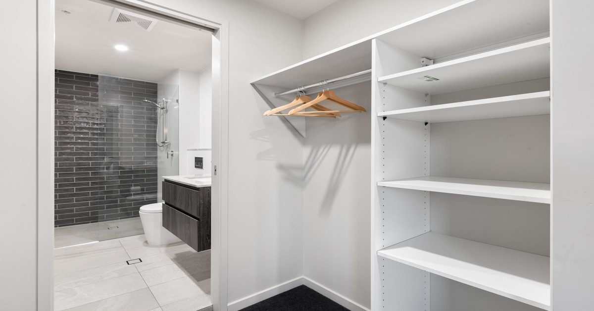 A budget-friendly walk-in closet with wire shelving, hanging rods, and organized bins on shelves